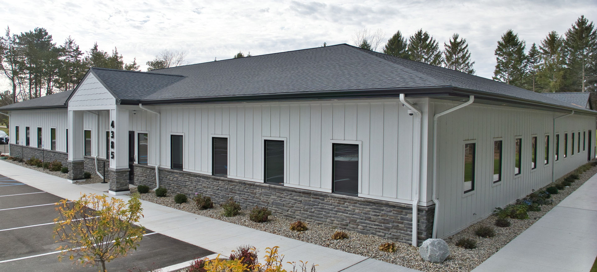 Single-storey commercial building with stone base and metal roof